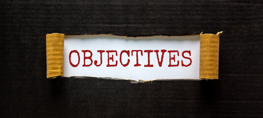 Objectives symbol. The word 'objectives' appearing behind torn black paper. Beautiful background....