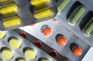multi-colored tablets in foil blisters lie on a light background. close-up.