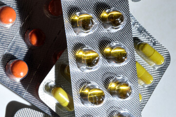 multi-colored tablets in foil blisters lie on a light background. close-up.