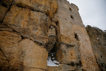 Scenic view of ancient ruins of old gothic medieval castle Helfenburk u Usteka with stone tower under snow in winter day, battlement ring walls, North Bohemia, Czech Republic