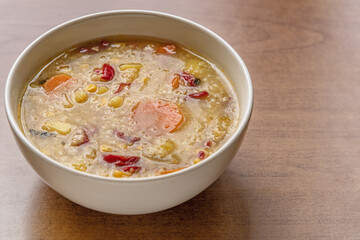 hearty vegetarian vegetable soup with bulgur and corn in a ceramic bowl