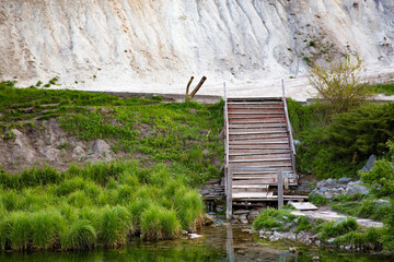 Lonely staircase from the lake on the background of the chalk mountain