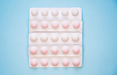 Pills packed in blisters on a blue background.