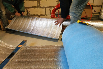 the installer and auxiliary worker wraps the air duct with mineral wool and foil