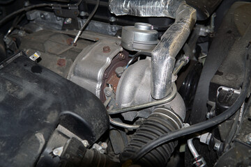 Fototapeta na wymiar The turbocharger is installed in the engine compartment of a modern powerful car.