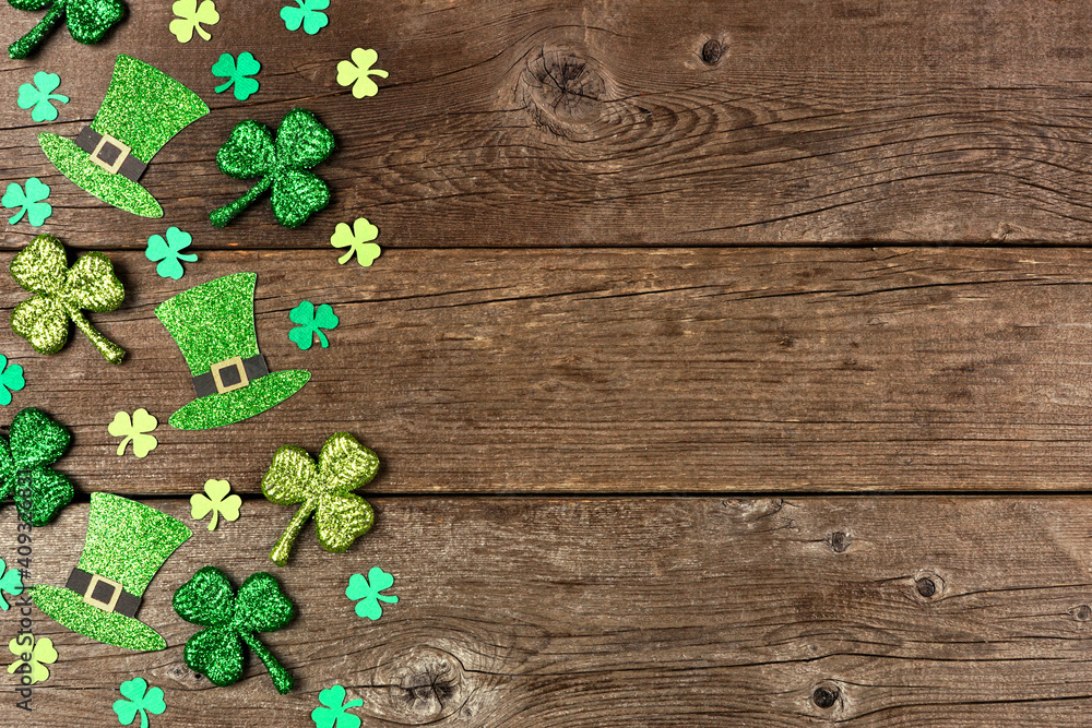 Poster St Patricks Day shamrock and leprechaun hat side border. Above view over a rustic wood background with copy space.