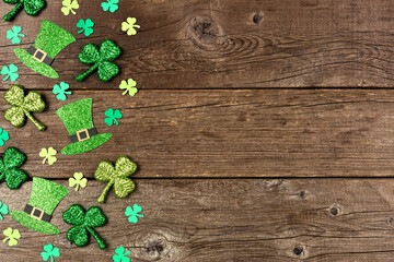 St Patricks Day shamrock and leprechaun hat side border. Above view over a rustic wood background...