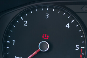 Natural light. the dashboard of the car. The handbrake indicator is on. Close-up.