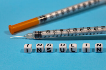 An insulin syringe for the treatment of diabetes on a blue background and the inscription 