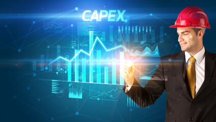 Handsome businessman with helmet drawing CAPEX inscription, architecture business plan concept