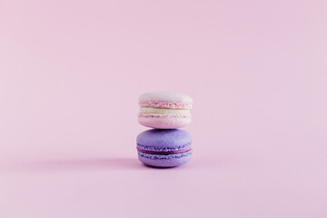 Tasty french macarons on a pink pastel background. Pink and violet macarons.