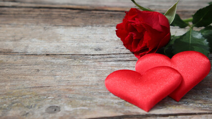 Banner. Red roses flowers with red hearts on old wooden background. Romantic Valentines holidays concept. Copy space. Top view.