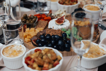 Cheese plate with chocolate, olives and grapes