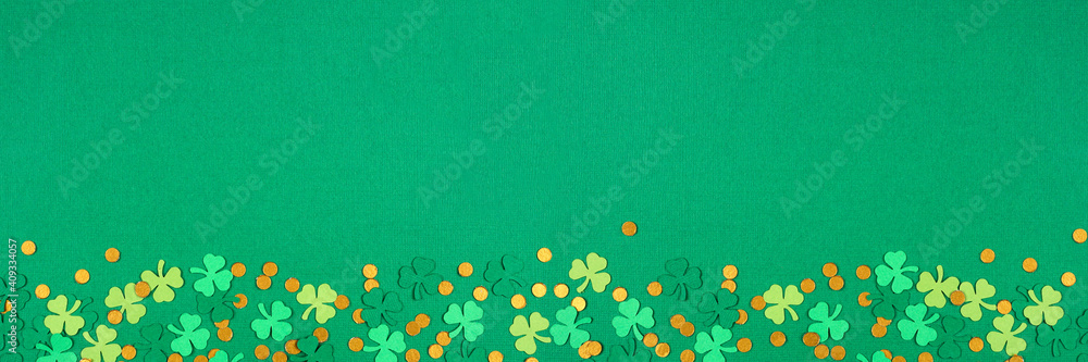 Poster St Patricks Day green background with shamrock and gold coin confetti bottom border. Top view banner with copy space.