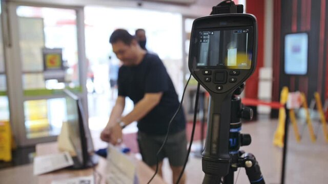 Temperature check at a supermarket, grocery store with a thermal imaging camera installed. Image monitoring scanner to monitor the body temperature of visitor customer. Coronavirus pandemic outbreak.