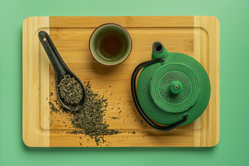 spoon with tea, green teapot and cup
