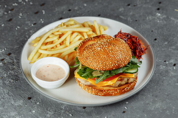 Turkey burger on a bun with cheese, lettuce, tomatoes and fresh cucumber. Burger with cutlet of...