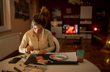 Fototapeta premium Girl doing crafts at home by night