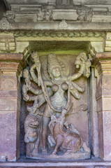 Fototapeta na wymiar Aihole, Karnataka, India - November 7, 2013: Durga Gudi or Temple. Gray stone statue of Durga as Mahishasuramardini in fighting mode killing the buffalo.