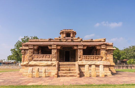 Aihole, Karnataka, India - November 7, 2013: Lad Khan Temple under blue sky. Brown stone building with green foliage on sides.