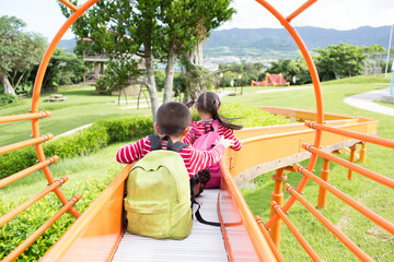 Kids (brother and sister) playing on the slide at Banna Park on Ishigaki Island, Okinawa, Japan.