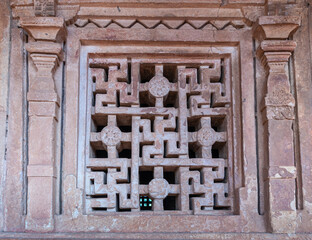 Aihole, Karnataka, India - November 7, 2013: Closeup of window screen filled with swastikas in...