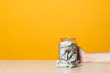 Money in the Bank, deposits and accounts concept. Dollar bills in a glass jar