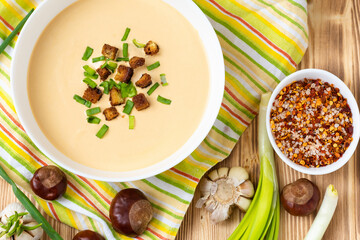 Wonderful cream soup of chestnuts on a wooden background.