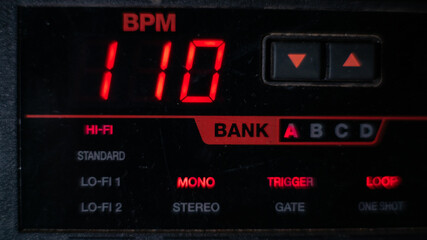 Fototapeta premium Macro detail of the liquid crystal display of a drum machine, 110 BPM. Red and black colors