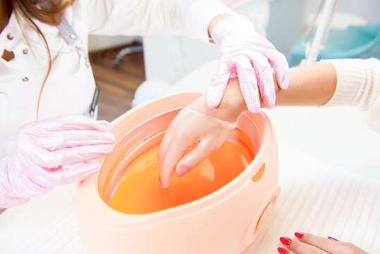 process paraffin treatment of female hands in beauty salon