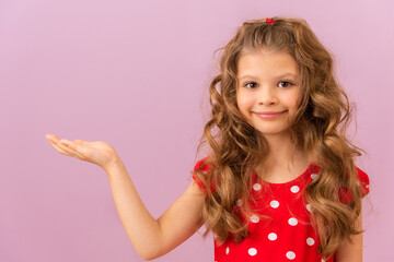 A little girl with curly hair points to the side.
