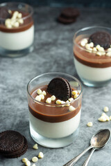 Panna cotta with chocolate, cookies and white chocolate in glasses. Delicious dessert.