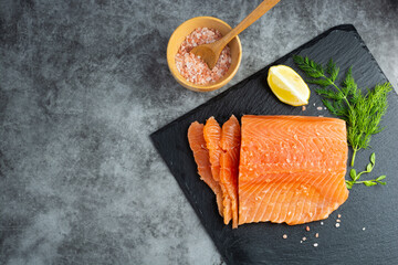 Fresh salmon fillet in a plate, top view. gray background. Copy space
