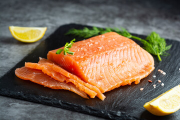 Fresh salmon fillet in a plate, top view. gray background.