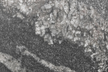 Dark gray stone granite or old marble slab surface with abstract wall texture background