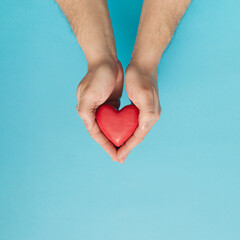 Obraz premium Red Heart Love is in Men's Hands.Concept for Valentine's day. Top view. Copy space.