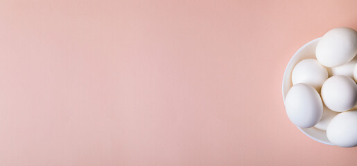 Easter eggs white on a pink background with place for text.
