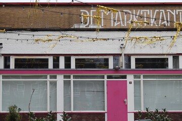 Fototapeta na wymiar Golden Garlands in Front of a Building with a Pink Door in Amsterdam