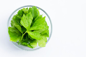 Chinese celery leaves in glass bowl on white