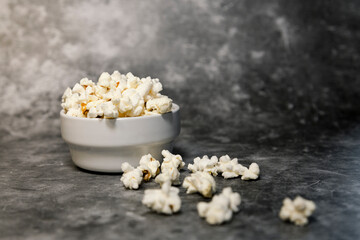 White bowl with popcorn on gray background
