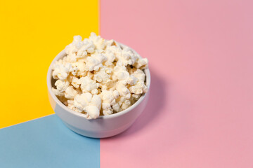 Bowl of popcorn on a yellow, pink and blue background