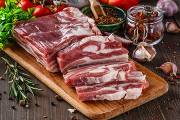 fat bacon on a wooden board. Close-up fat bacon with garlic and spices, homemade lard,Slices of bacon on a cutting Board. Pork meat.