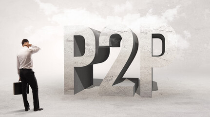 Rear view of a businessman standing in front of P2P abbreviation, attention making concept