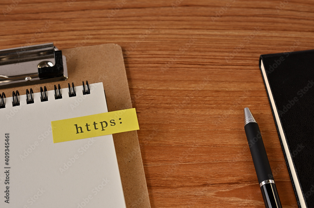 Poster there is a notebook, a pen, and a clipboard with a sticky note stuck to it that says https: written 