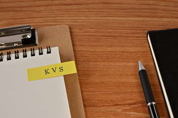 There is a notebook, a pen, and a clipboard with a sticky note stuck to it that says KVS written on it. It was an abbreviation for key value store.