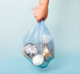 Separate collected metal garbage in garbage bag. Iron stuff for recycle on blue. Eco friendly...