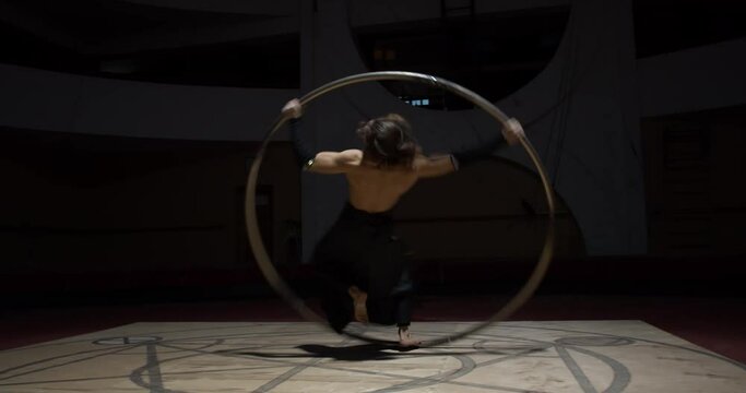 Stunning athleticism of a young man, spinning in a massive wheel, gymnastics, 4k