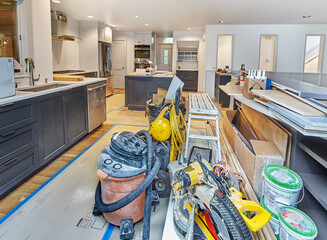 In-progress kitchen remodel with tools and supplies organized at the end of the day. Appliances and...