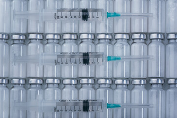 Obraz premium Medicine, Injection, vaccine and disposable syringe, drug concept. Sterile vial medical syringe needle. Macro close up. Glass medical ampoule vial for injection. Bottles ampule with aluminum cap.
