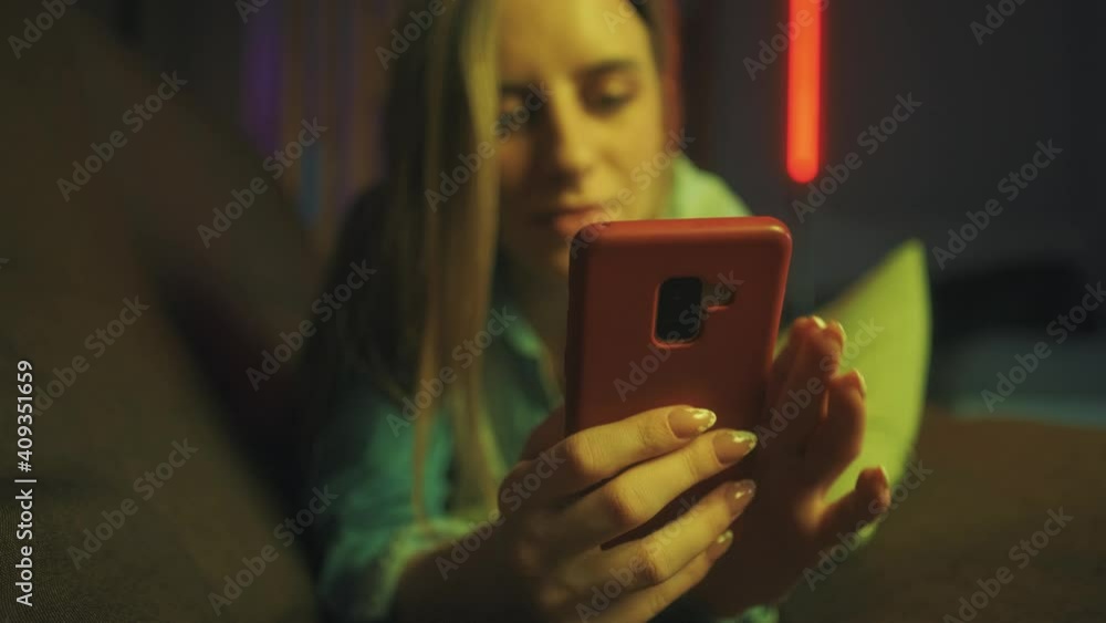 Poster a attractive smiling woman is typing text message and using smart phone on the sofa at home. concept